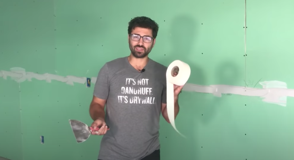 man showing you the process to tape a drywall 