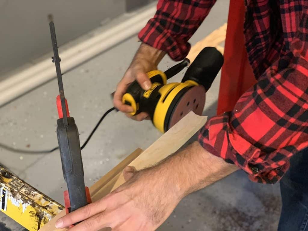 Orbital sander sanding a piece of wood