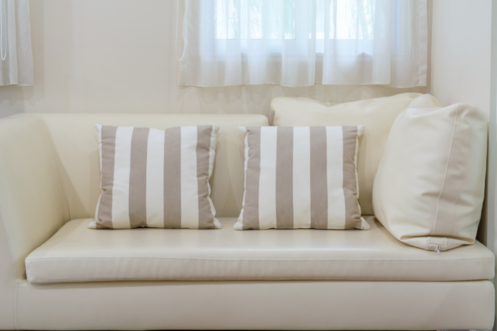 throw pillows on a white leather couch