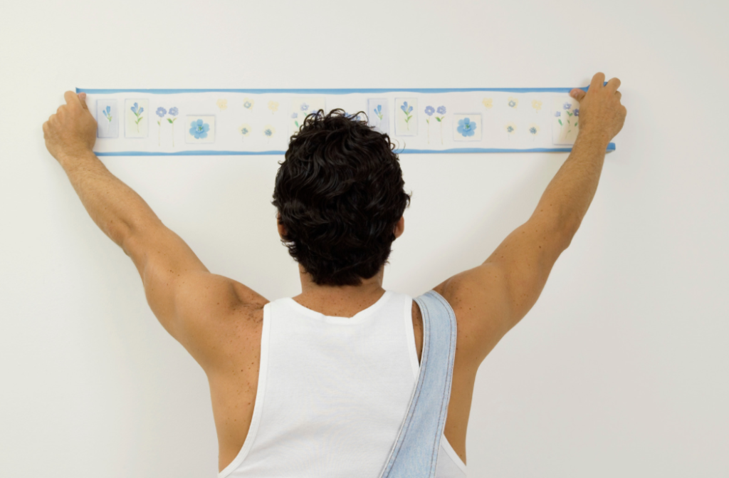 man hanging a poster on the wall