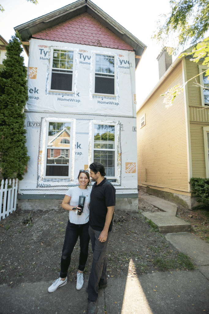 Two people standing in front of a house under construction.