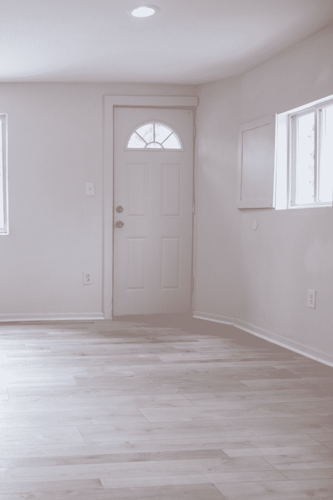 A white door leading into an empty apartment entryway.