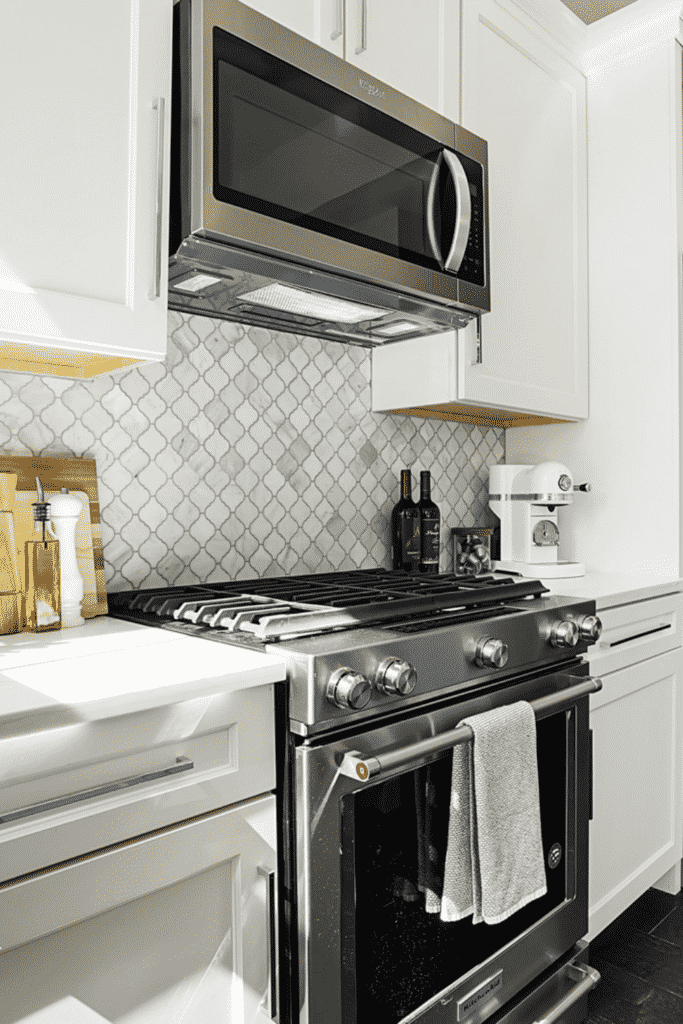 A kitchen oven and stove with an overhanging microwave and white cabinets