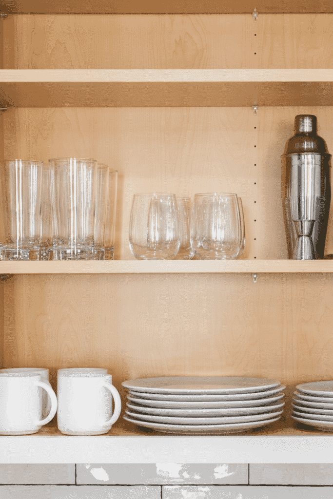 Cupboard shelves of glasses, plates, and coffee cups