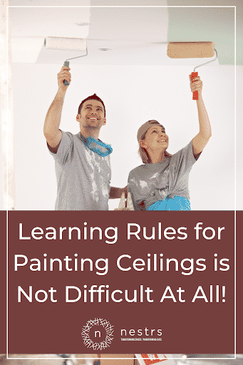 a couple painting the ceiling of their home