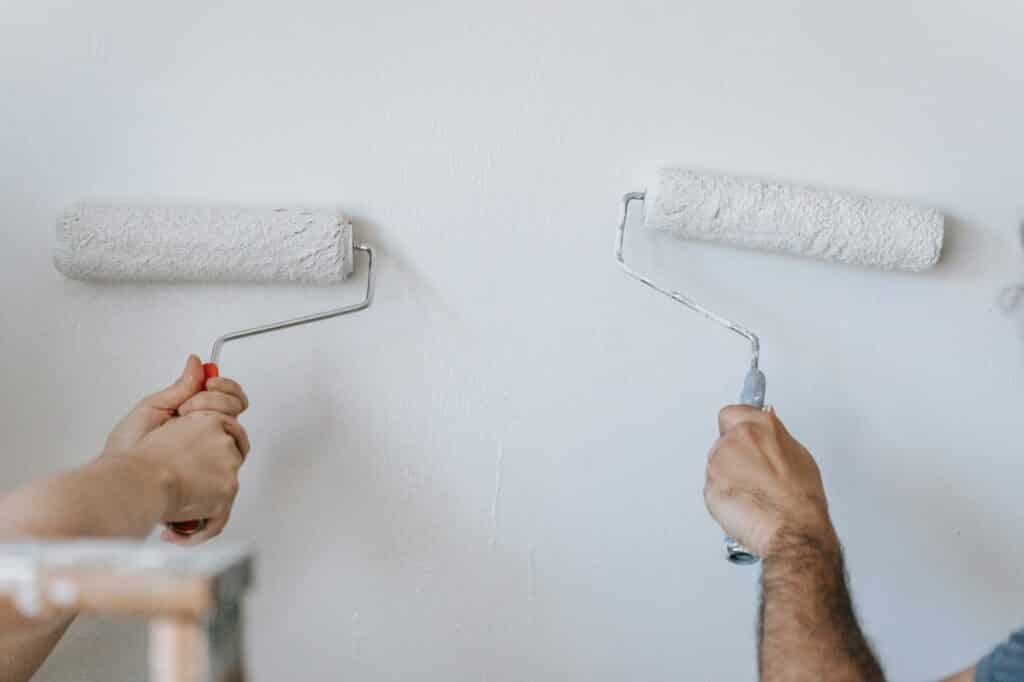 couple painting a ceiling with a roller