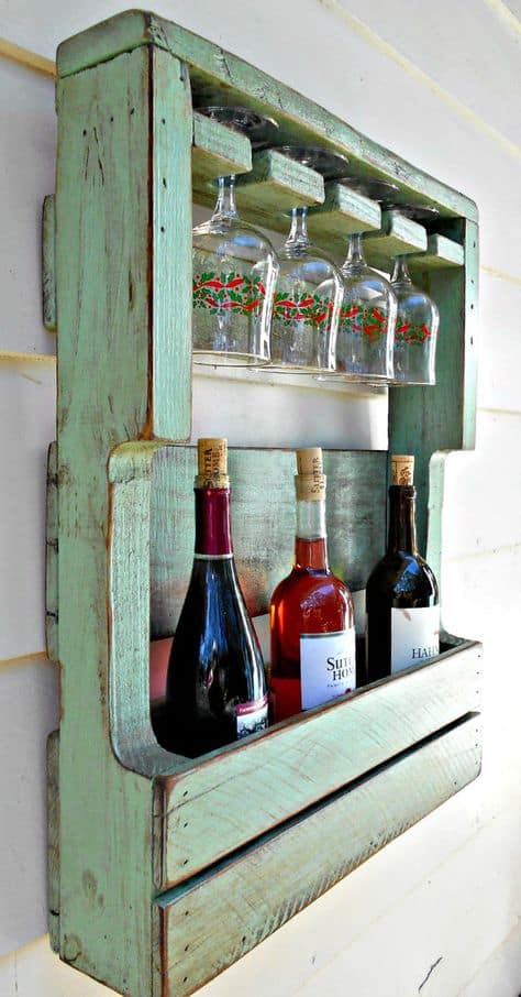 Rustic painted pallet wine rack nailed to a wall.